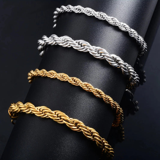 Close-up of gold and silver chain bracelets on a black display.